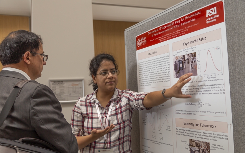 Pallavi, presenting a scientific poster to someone.